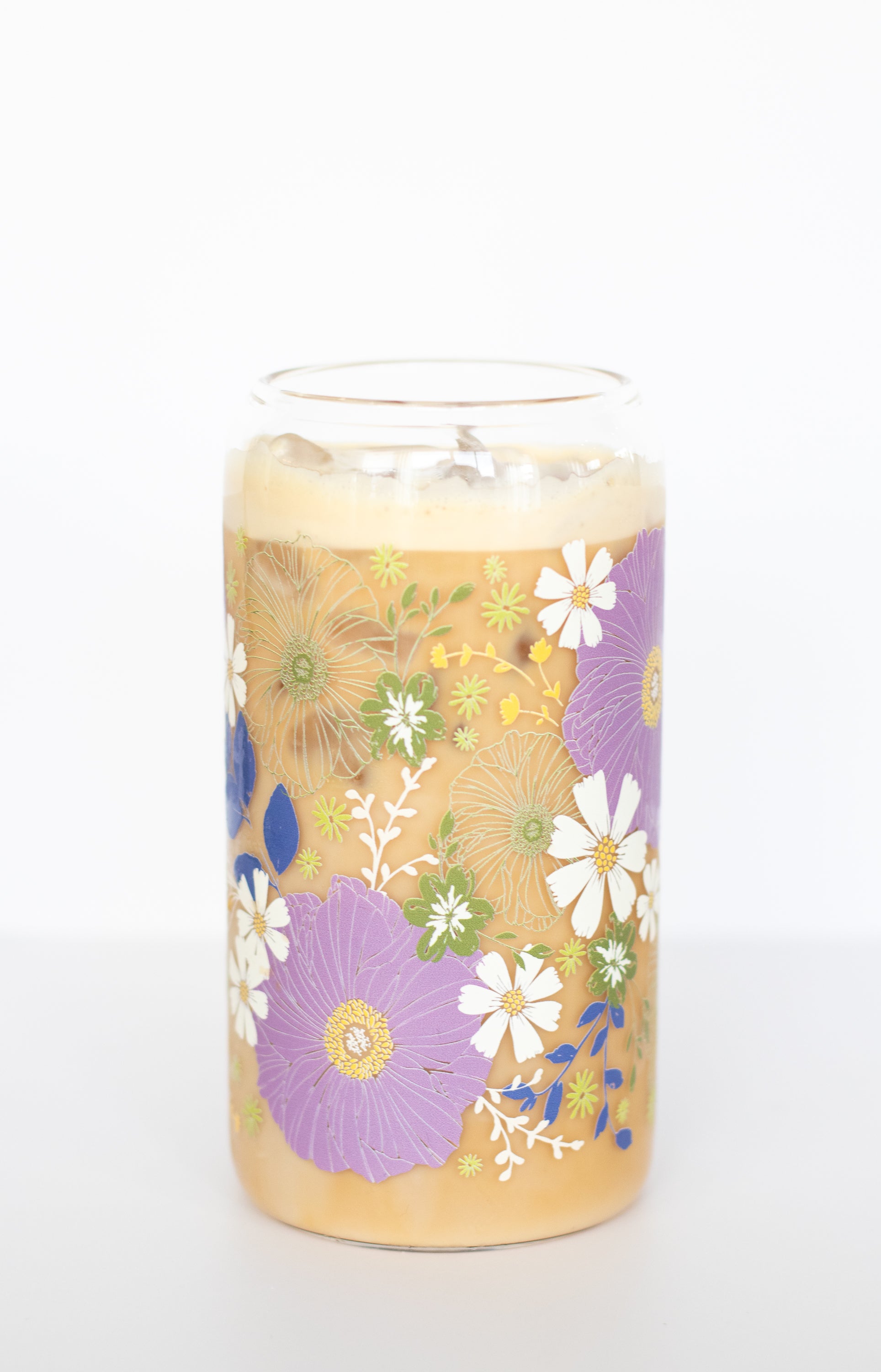 A can glass with a purple anemone and white daisy floral design on a white background.