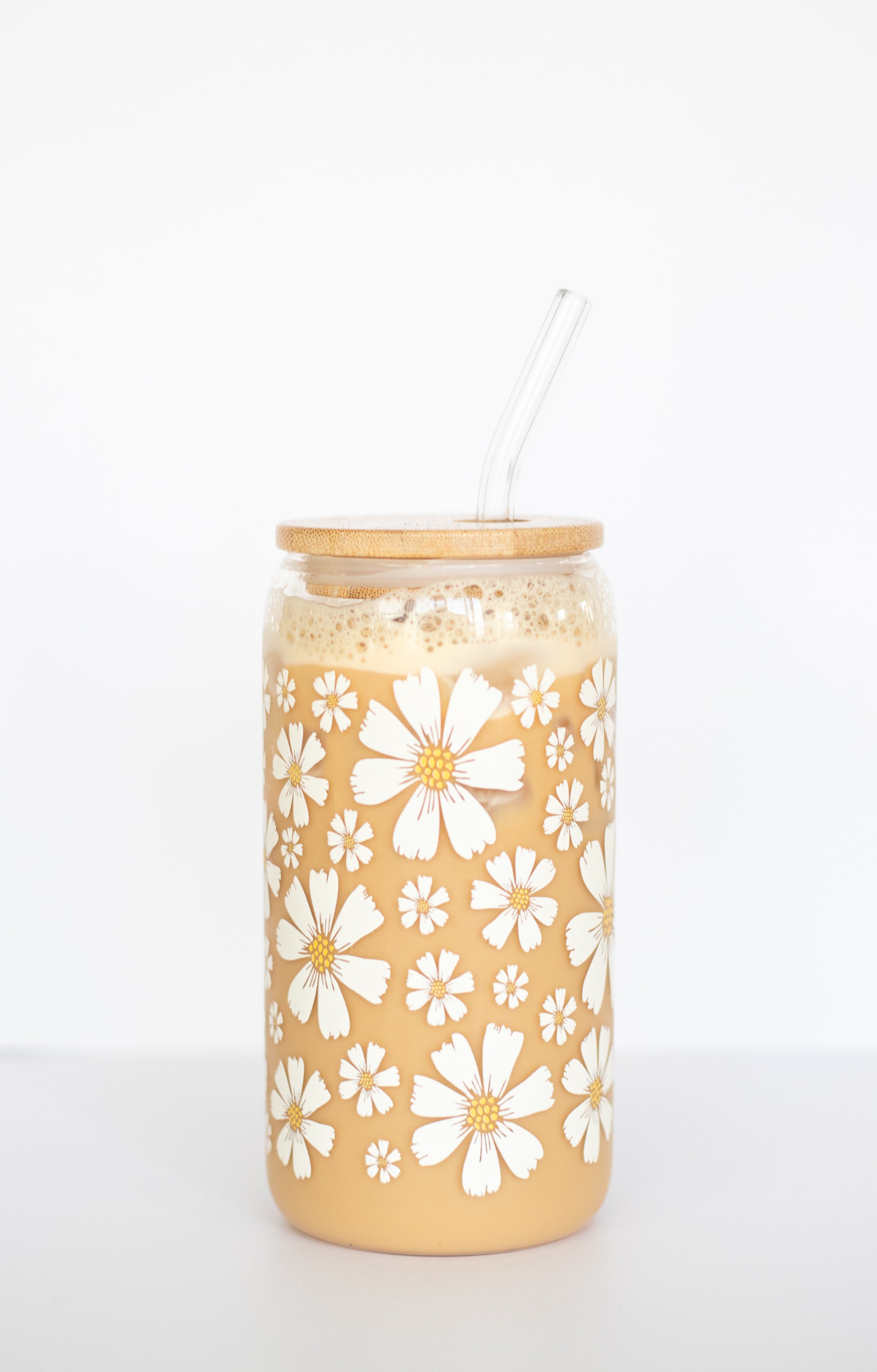 Can glass with a white floral pattern against a white background.