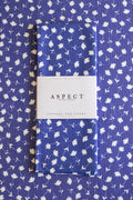 A folded waffle-weave kitchen tea towel with an indigo blue and white floral pattern, wrapped in a white paper belly band labeled 'ASPECT HOME GOODS' and 'kitchen tea towel', laid flat on a matching patterned blue surface.