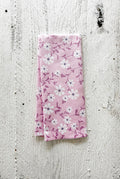 Spring blossoms floral waffle-weave lavender kitchen towel lavender botanical dish towel on a white wooden surface.