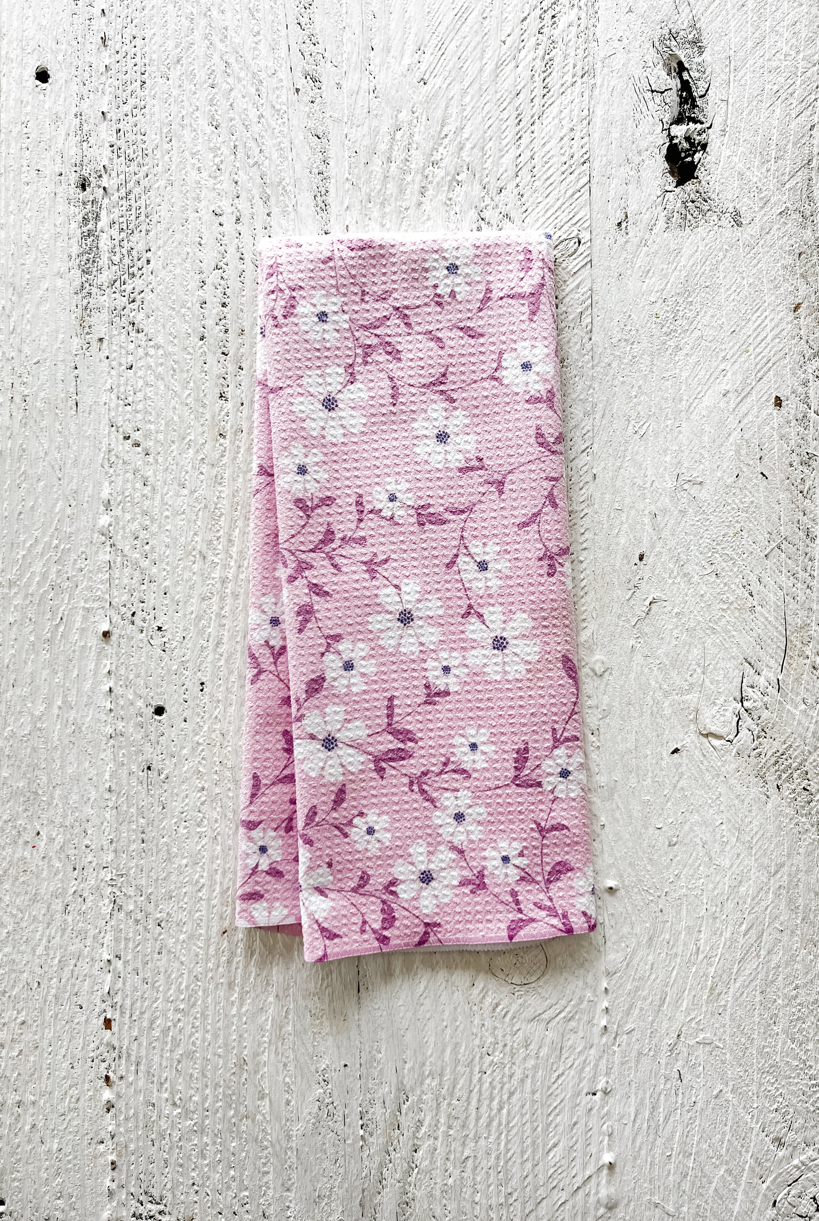 Spring blossoms floral waffle-weave lavender kitchen towel lavender botanical dish towel on a white wooden surface.