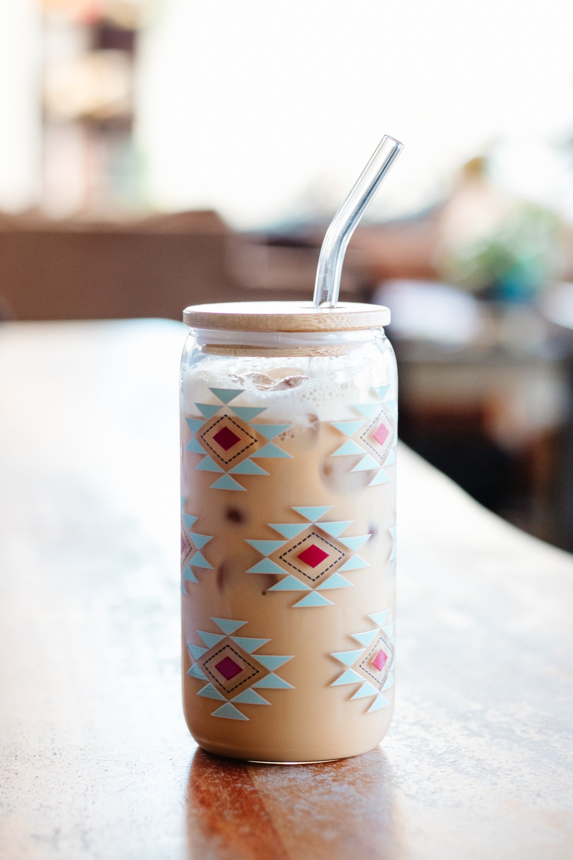 Iced coffee in a can glass with a southwestern geometric pattern on a blurred background